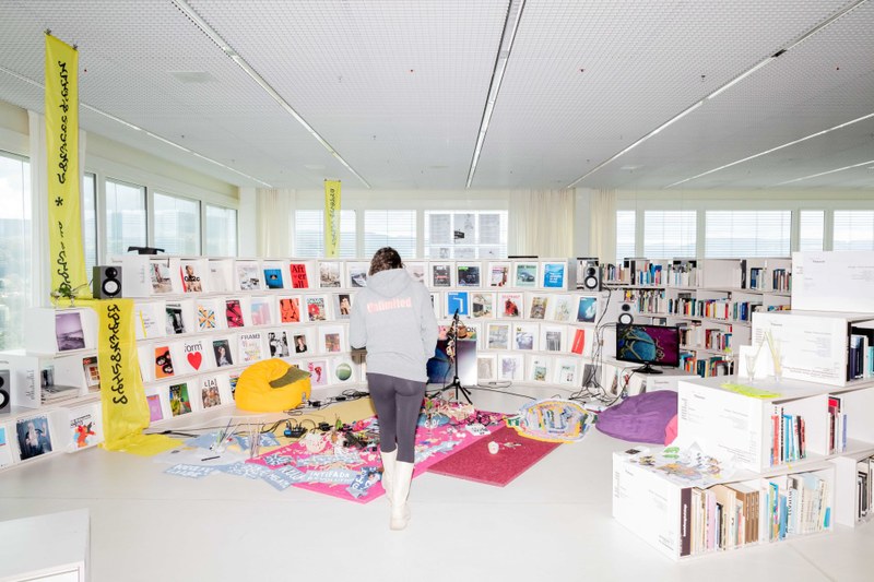 Eine Frau steht vor einem Regal mit Medien