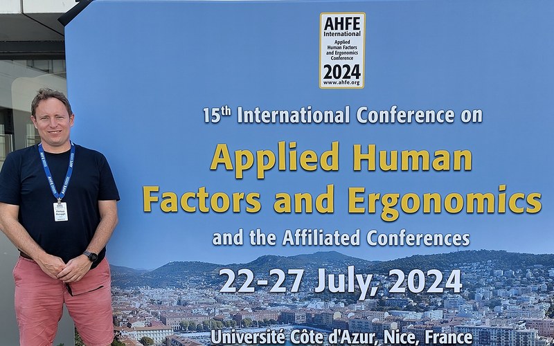 Philipp Renggli posiert vor dem Plakat des Best Paper Awards in Nizza.