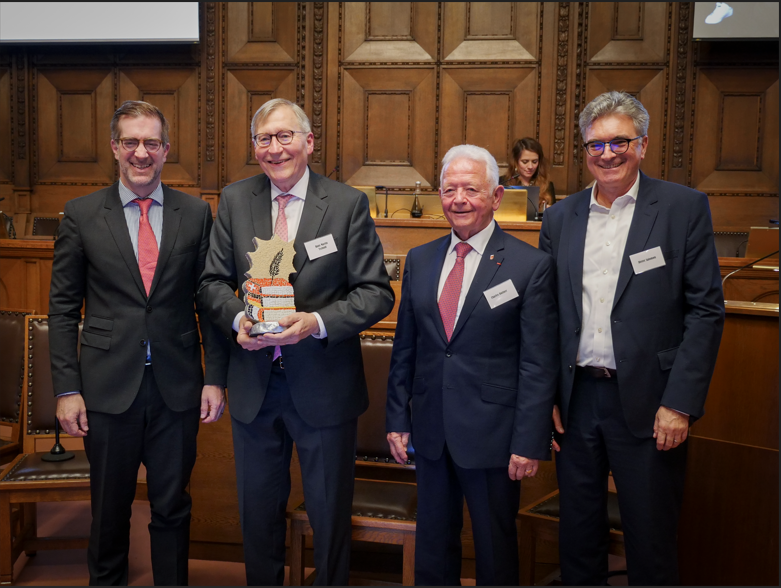 Hans Marti Tschudi posiert mit drei weiteren Personen nach dem Gewinn des Ehrenpreises.