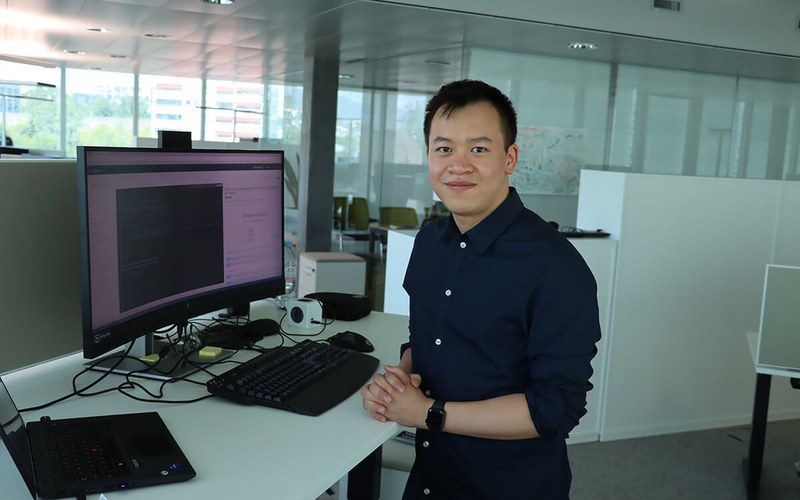 Kenny Cheung steht vor seinem Computer im Büro der Hypothekarbank Lenzburg