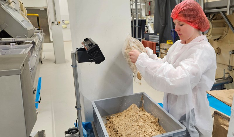 Eine Mitarbeiterin wiegt und kontrolliert das trockene Hefepulver