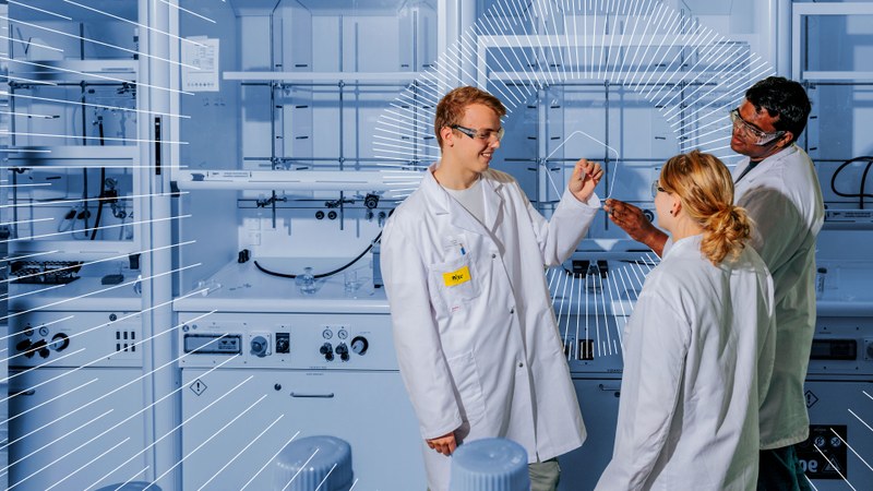 Drei Personen mit weissen Laborkitteln in einem Labor