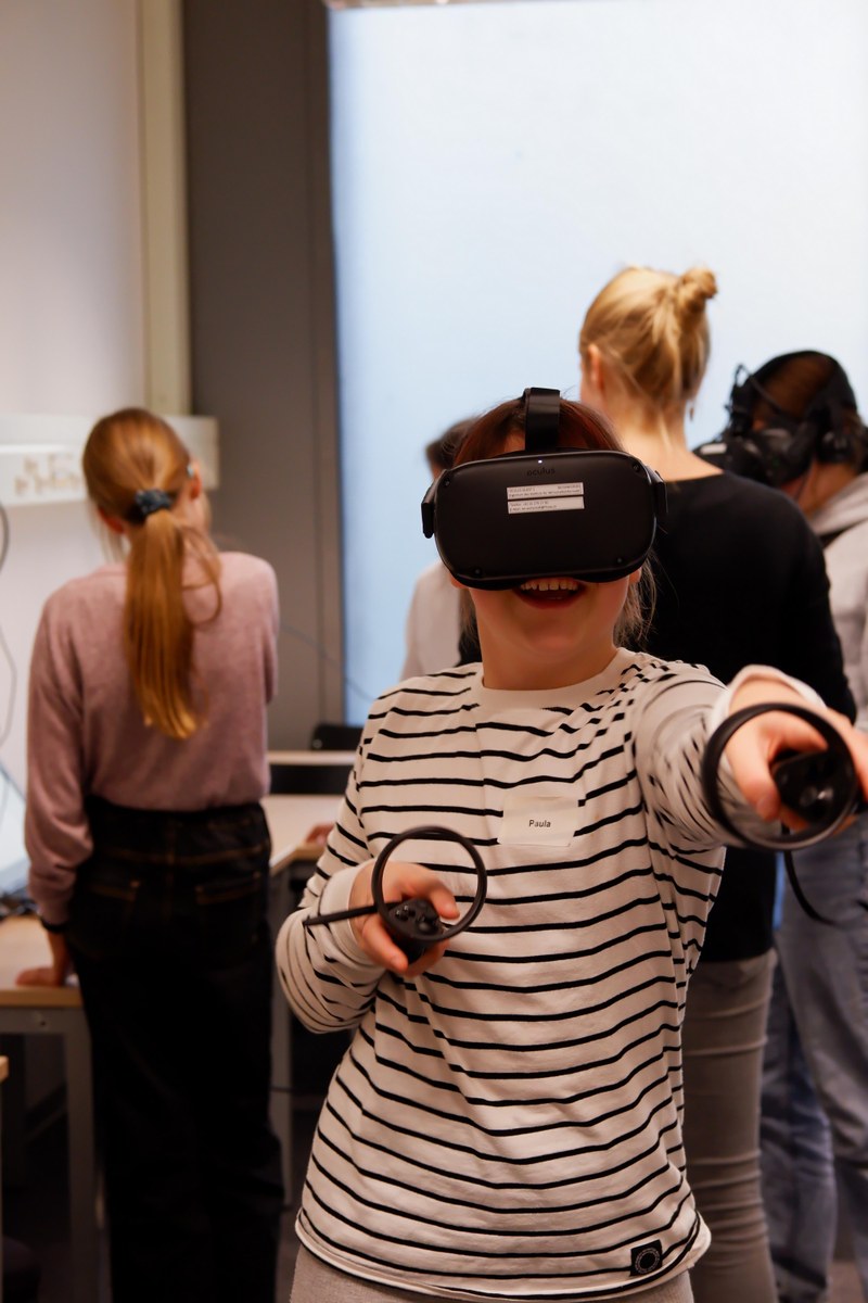A girl wearing a virtual reality headset and two controllers