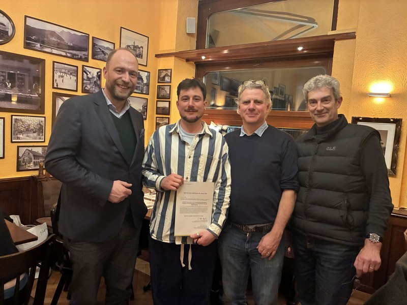 Gruppenbild. Antonio hält dir Urkunde für die beste Bachelorarbeit in den Händen