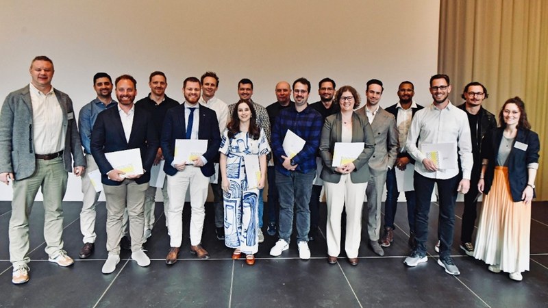 Gruppenbild der lachenden Absolvent*innen. Manche haben ihr Diplom in der Hände.