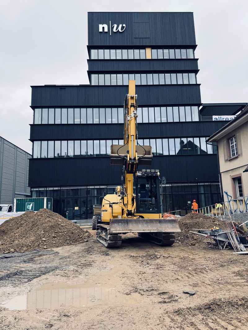 Ein Bagger vor dem neuen FHNW Campus Dreispitz in Basel.
