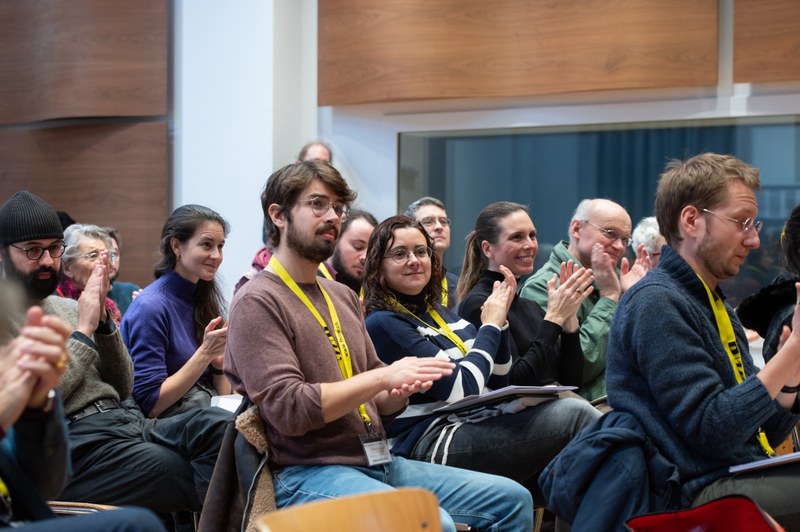 Teilnehmende einer Konferenz applaudieren