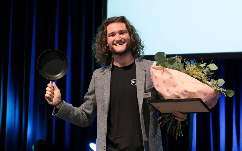 Dominik Müller hält eine Pfanne und einen Blumenstrauss in der Hand