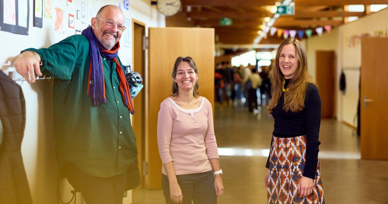 Übermüdeter Arzt in Spitalkleidung am Computer beim Schreiben von Krankenberichten.