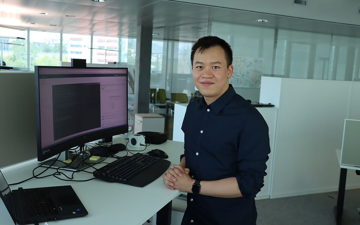 Kenny Cheung steht vor seinem Computer im Büro der Hypothekarbank Lenzburg