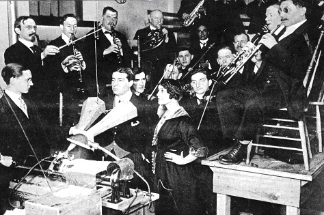 Two singers and musicians recording with a phonograph.