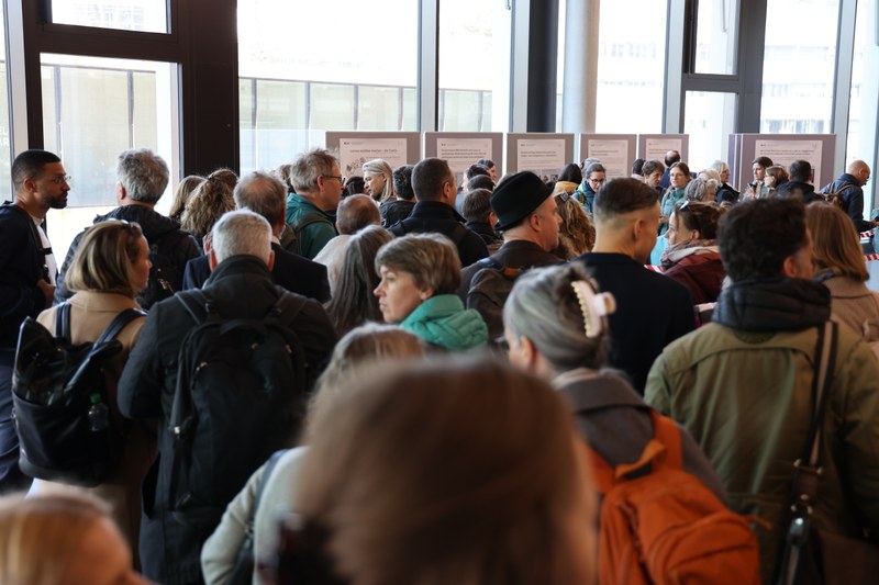 Im Foyer des Campus Brugg-Windisch stehen dicht gedrängt ca. 40 Menschen. Blick von hinten in die Personenmenge.