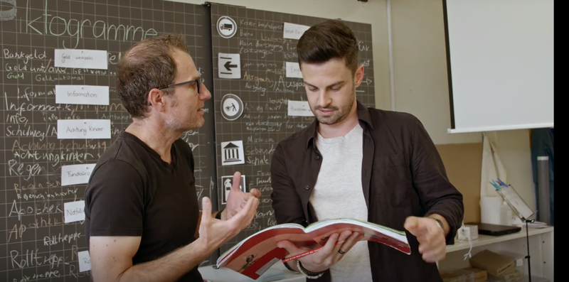 02_Gemeinsames Planen von Unterricht_Serdar Arbeitsbuch haltend.PNG