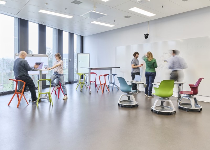 Ein modularer Lernbereich am FHNW Campus Brugg-Windisch. Tische und Stühle sowie Smartboards sind zu Lerninseln gruppiert. Studierende arbeiten in kleinen Gruppen