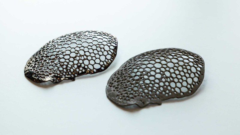 Titanium alloy cranial plates manufactured using selective laser melting (SLM). Left: Surface after automated electropolishing and smoothed surface morphology. Right: Sandblasted reference surface with induced microtopography.